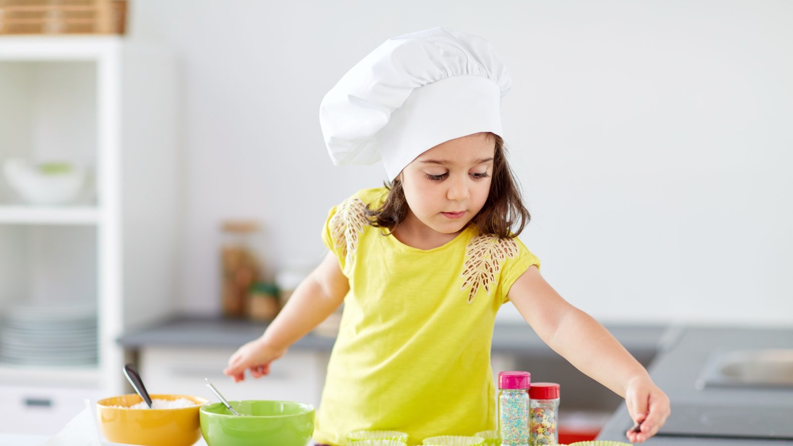 A girl in a chef hat baking