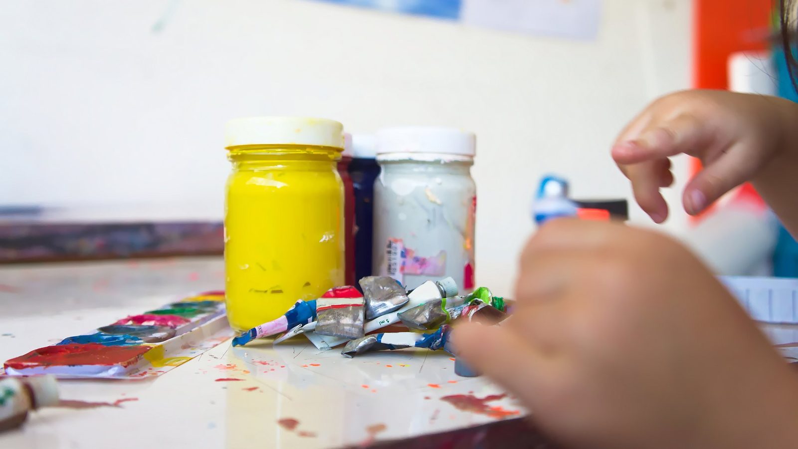 Hands opening pots of paint