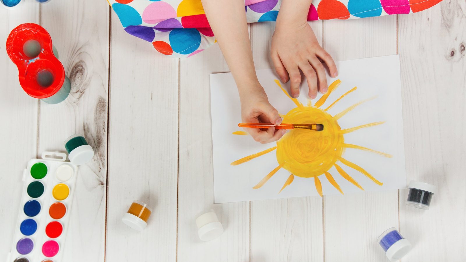 Hand painting a sun with watercolours