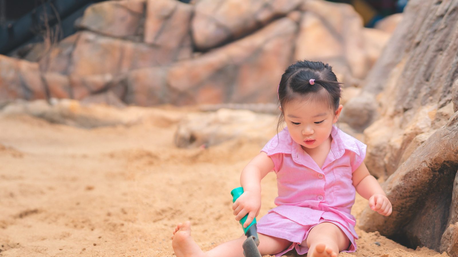 A toddler playing in the sand