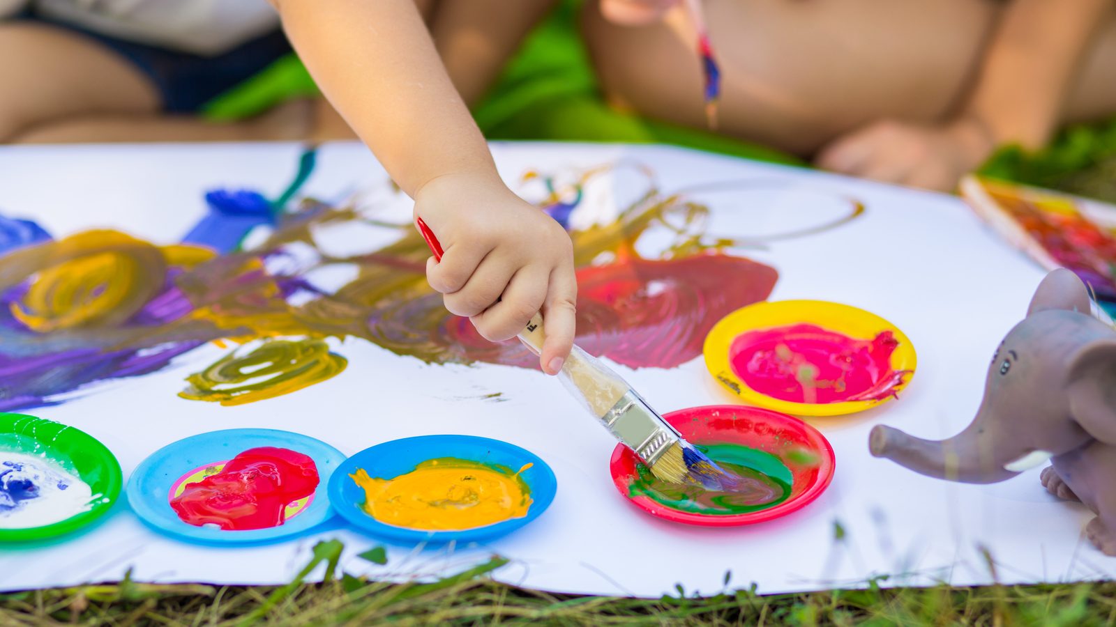 Hands painting with bright paints