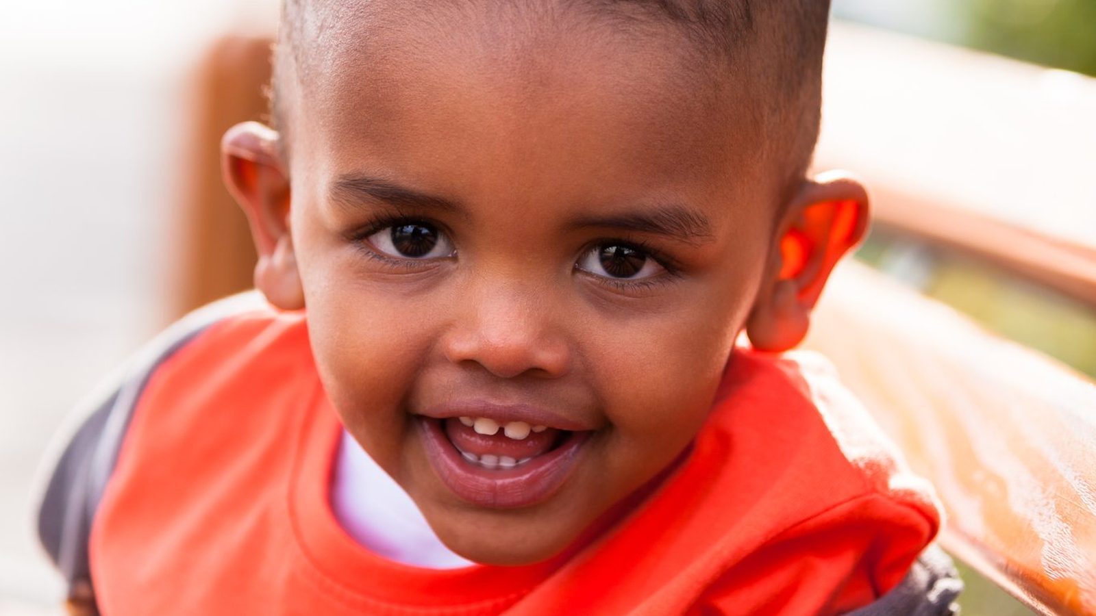 Smiling toddler in an orange top