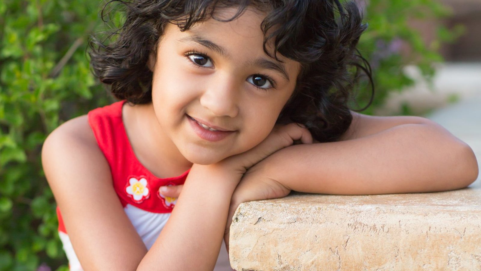 Girl leaning on a brick wall