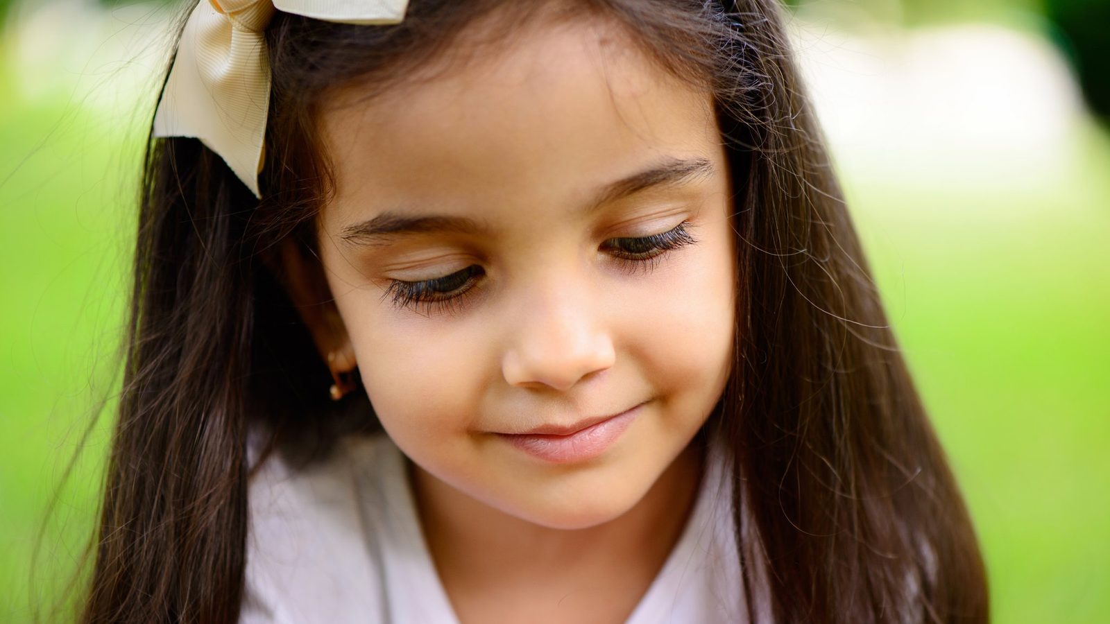 Girl looking down and smiling in a garden