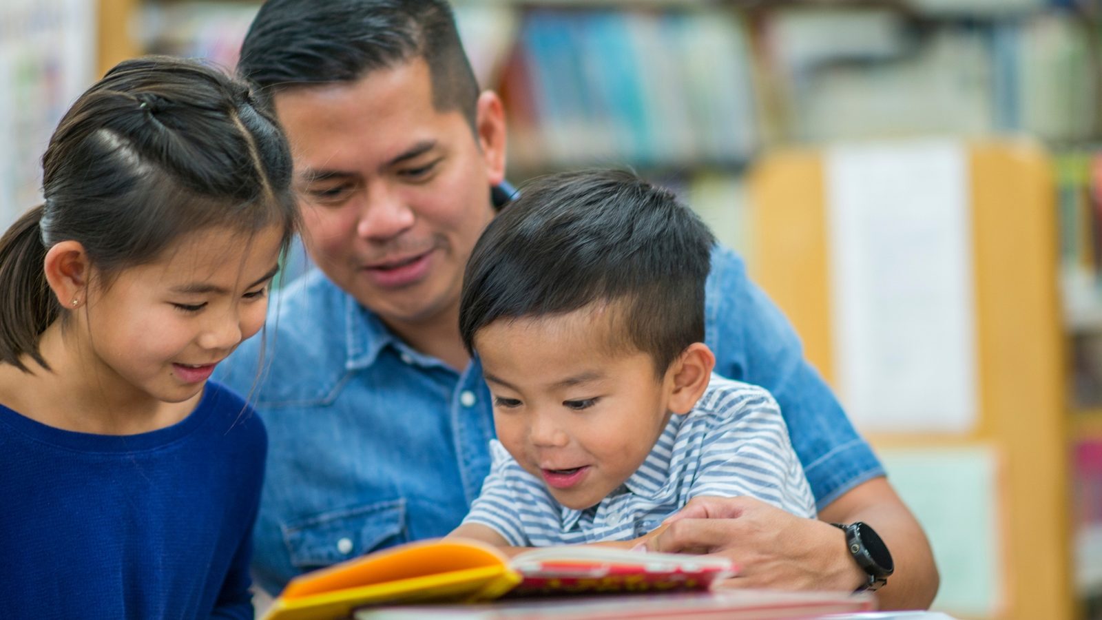 A father reading picture books with his young children