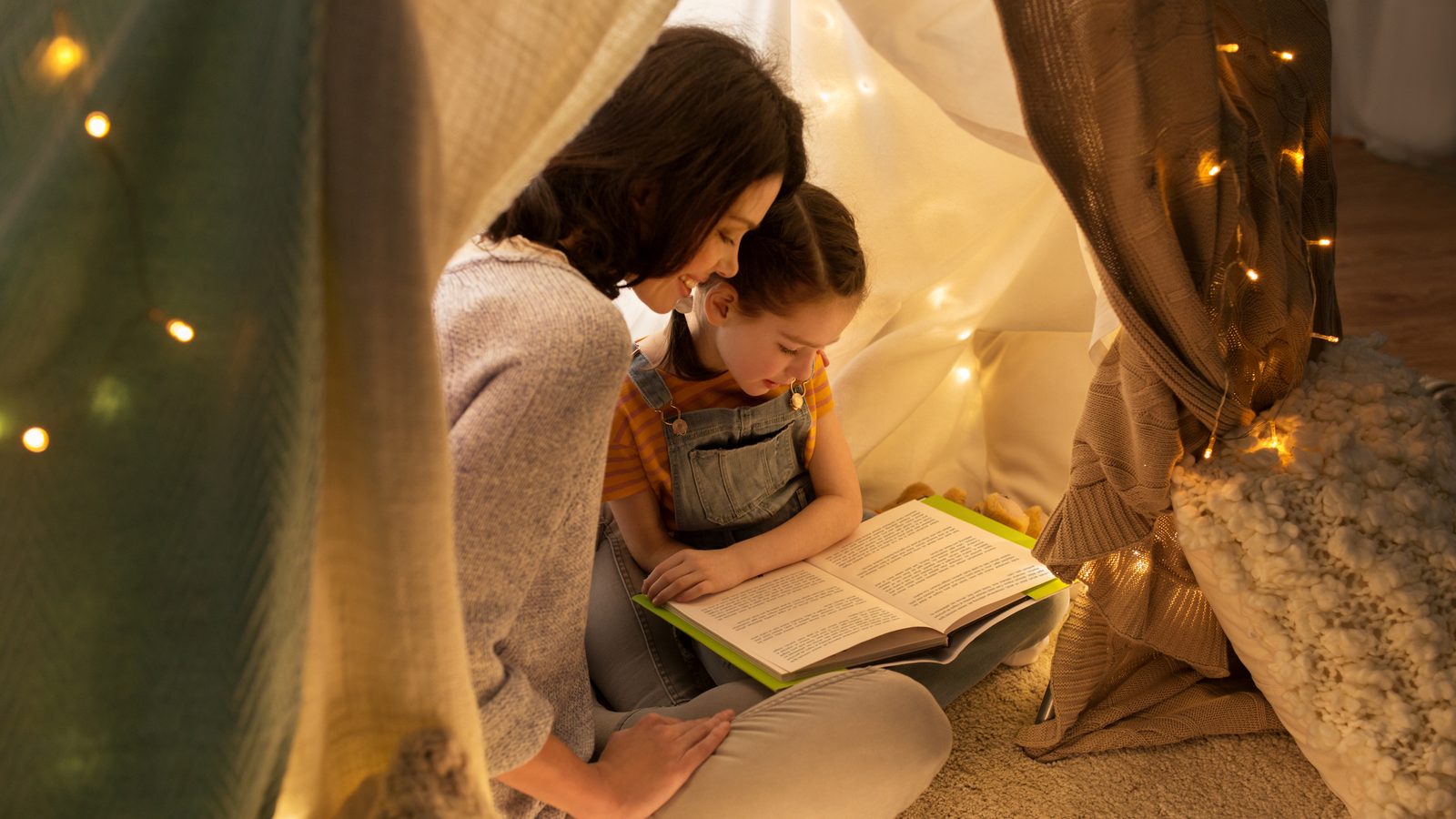 A girl reading inside a play tent
