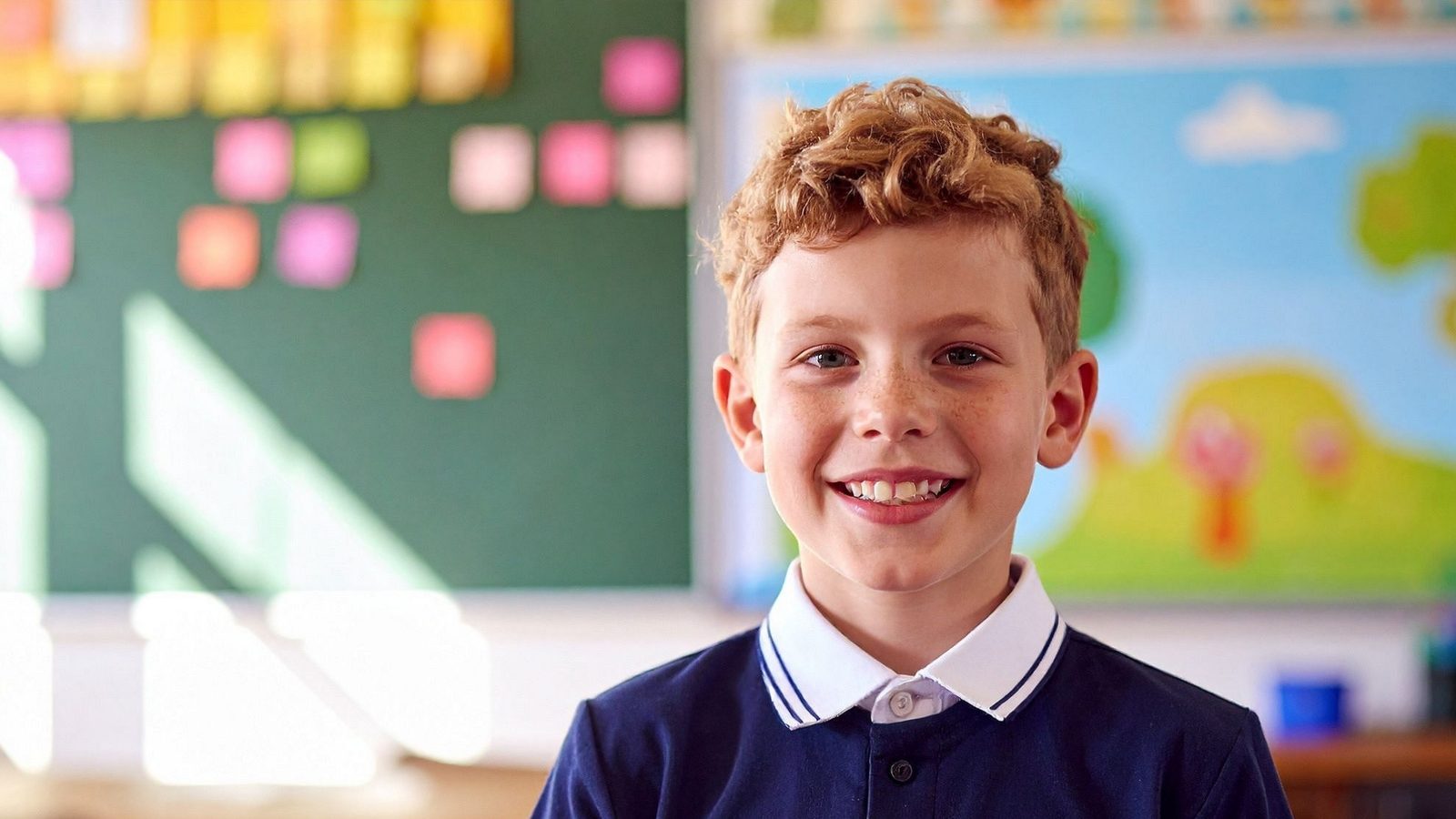 A smiling boy in a kindergarten classroom