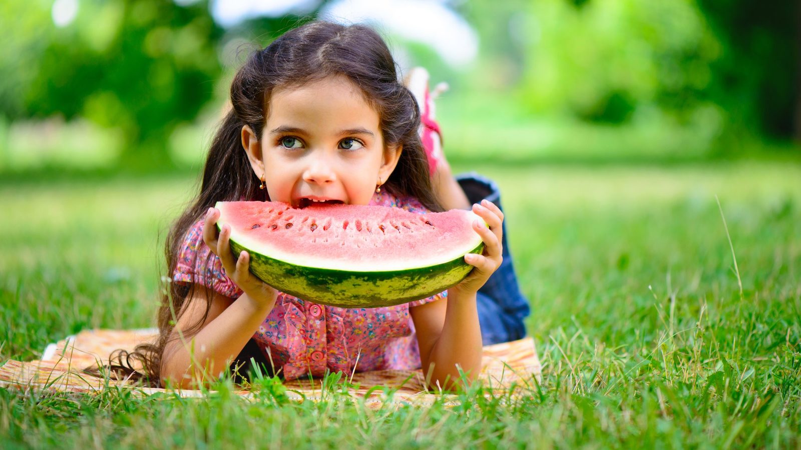 Girl eating watermelon on the grass