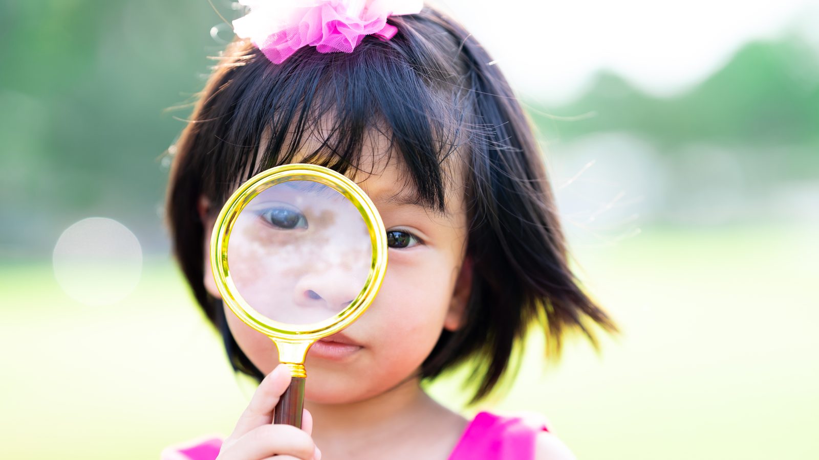 A girl looking through a magnifying glass