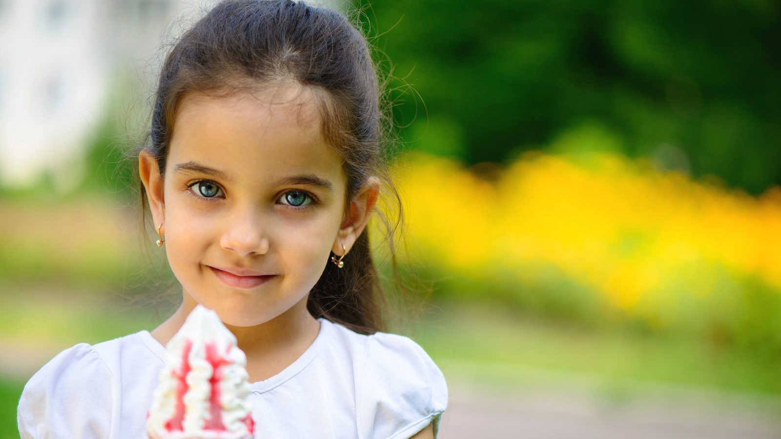 Smiling girl holding an ice cream outdoors