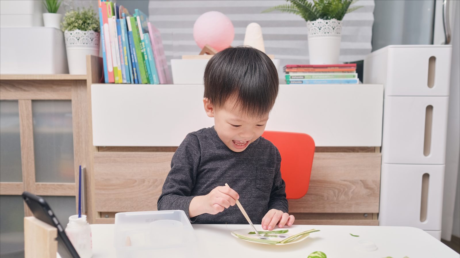 A boy painting with a palette
