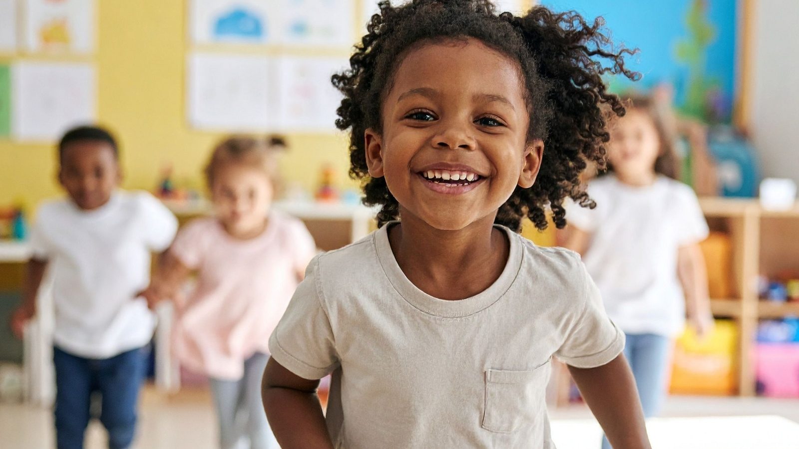 A laughing boy playing in a preschool classroom
