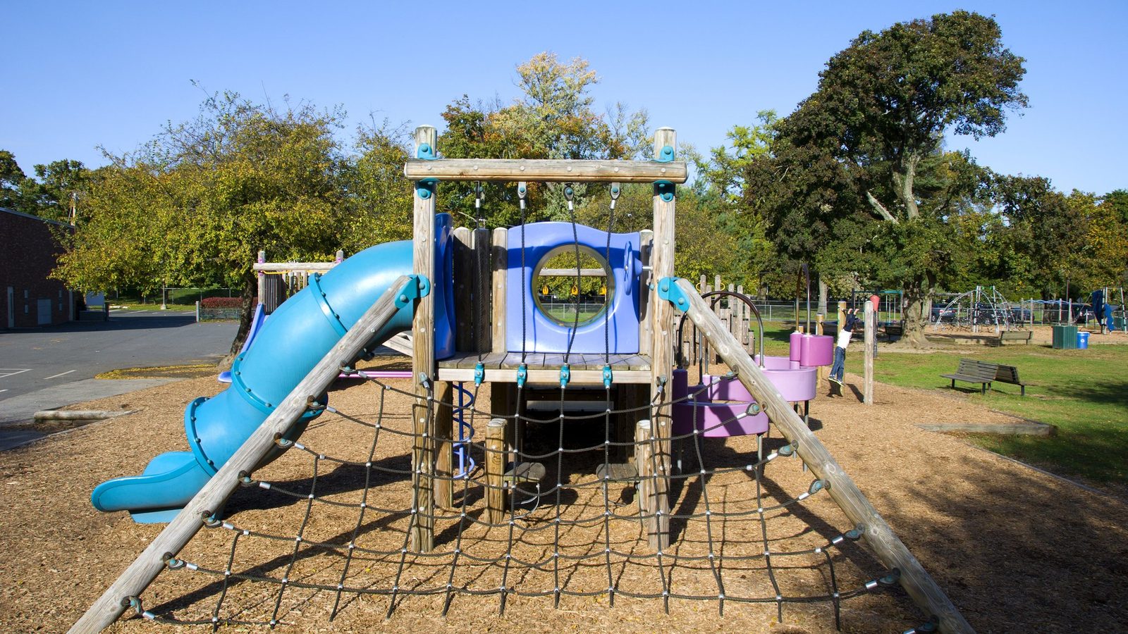 Empty outdoor playground with slides and a climbing net