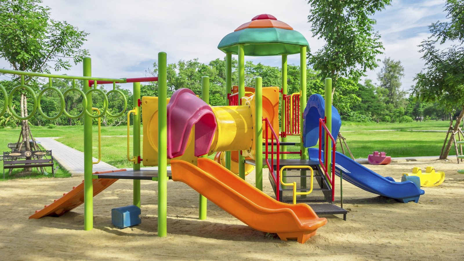 Empty colourful playground with slides on a lawn