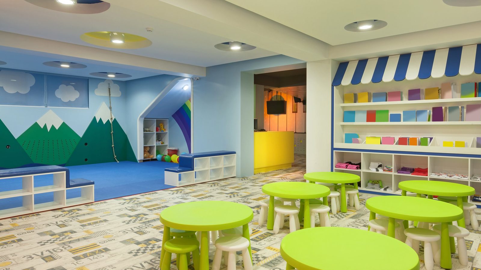 Empty preschool classroom with round green tables
