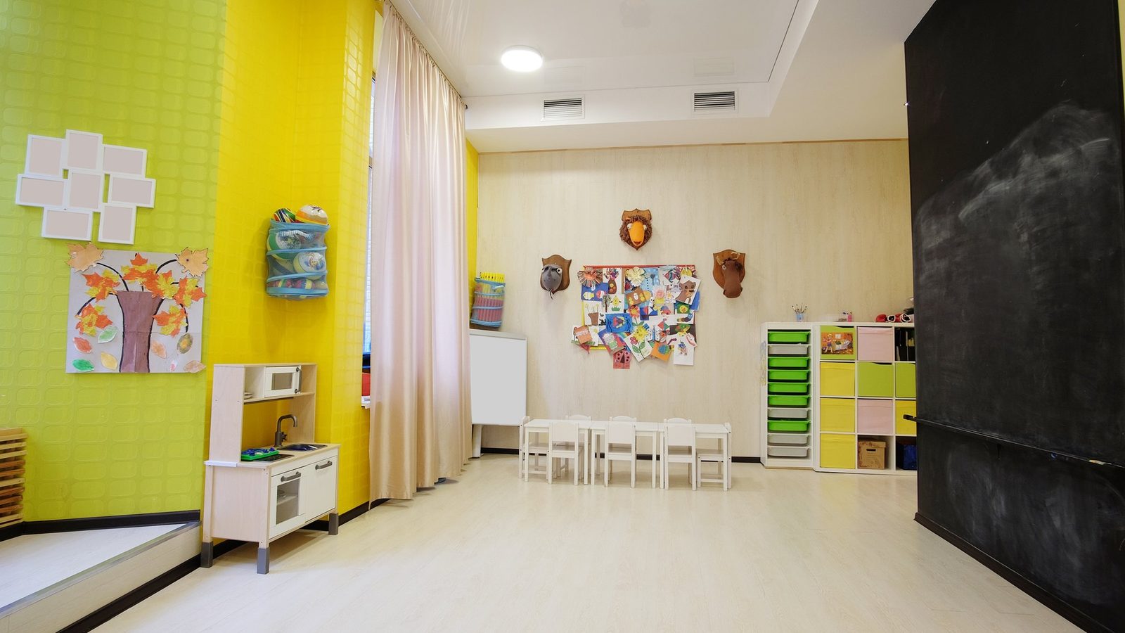 Empty bright classroom with yellow walls and a chalkboard
