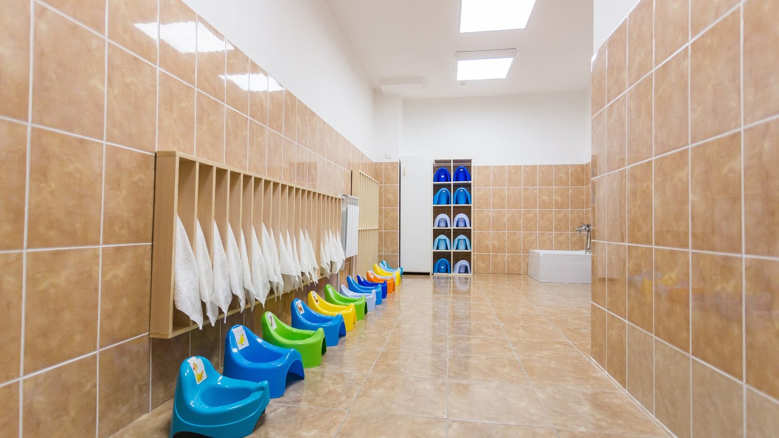 Empty school washroom with small colourful sinks