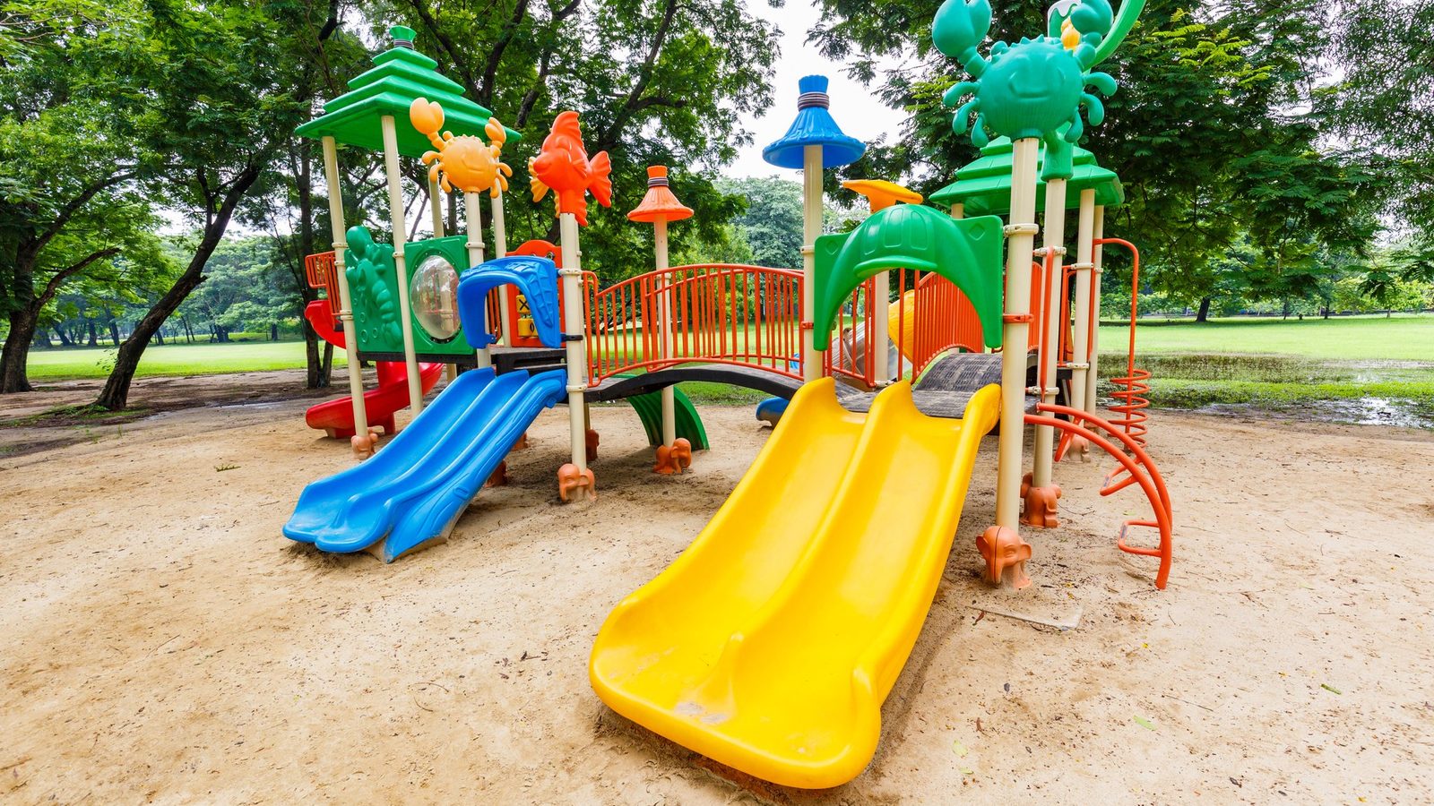 Empty playground with yellow slides on sand