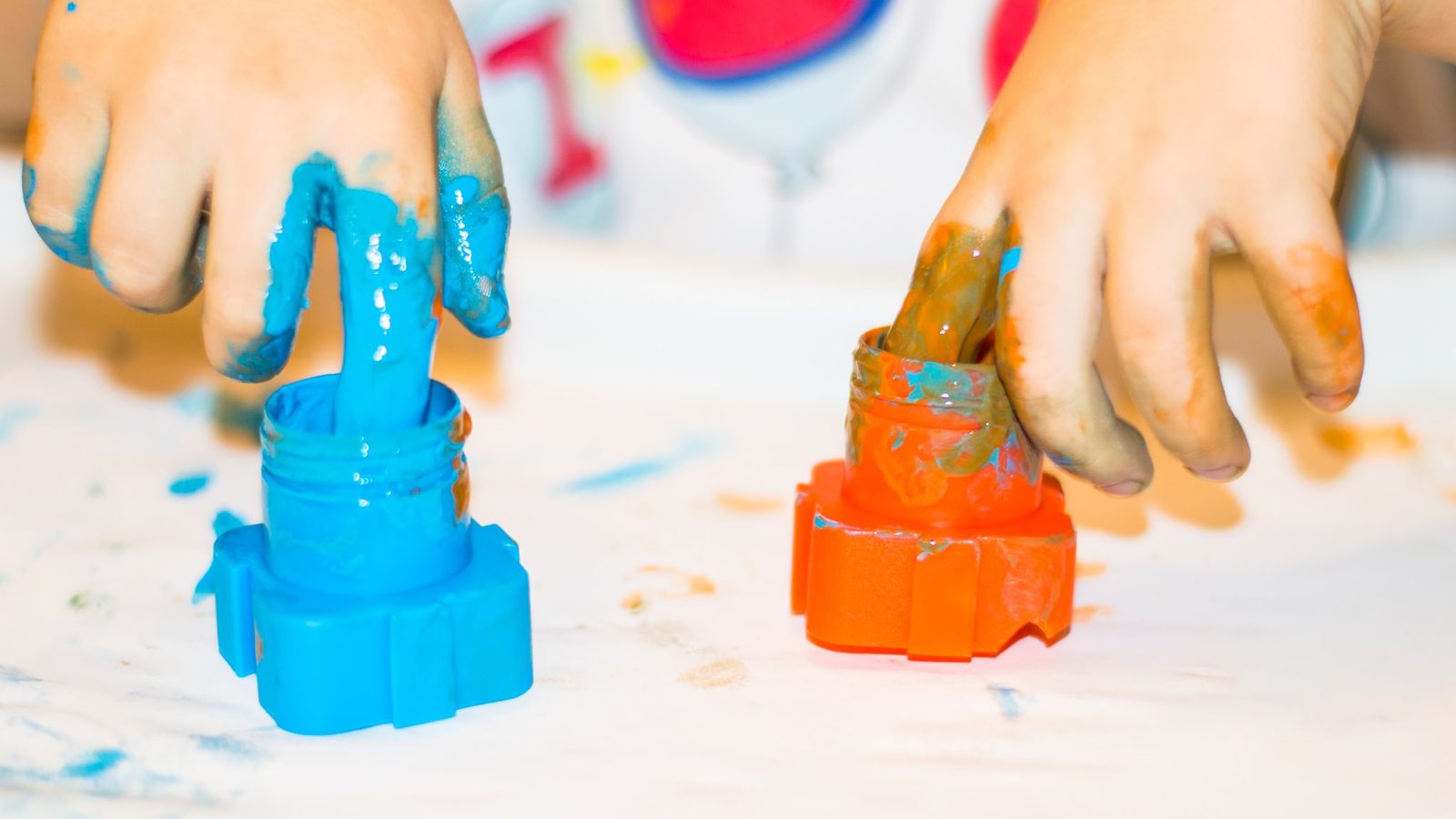 Hands covered in blue and orange paint